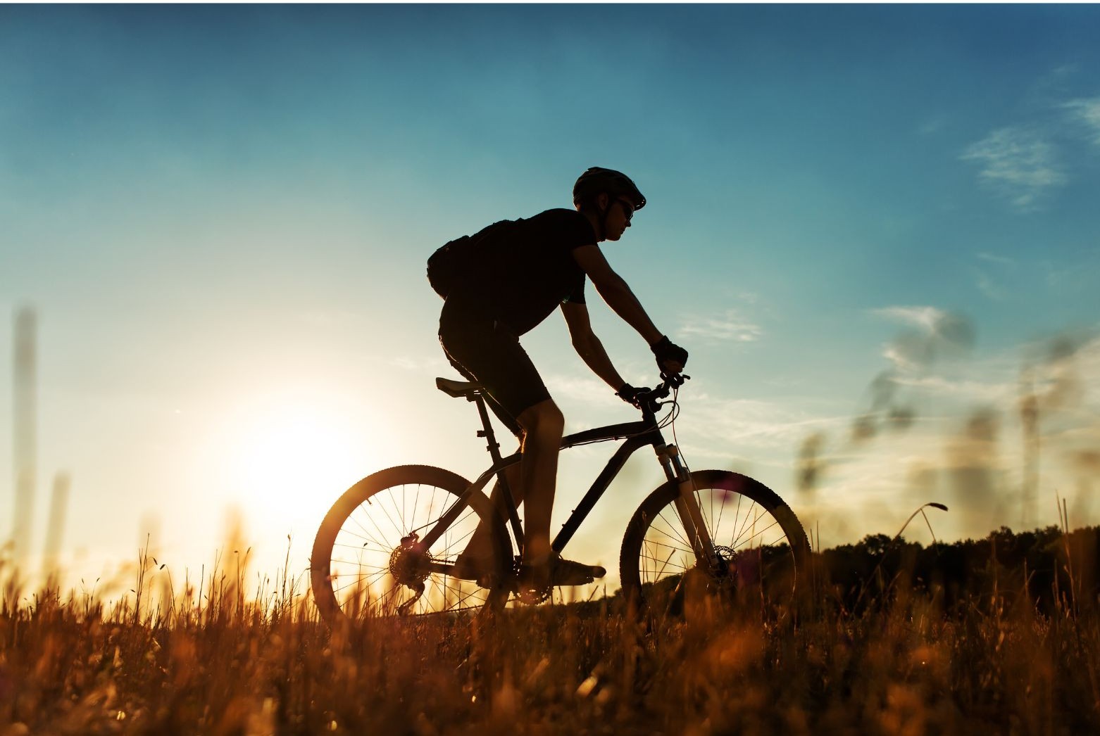 Obrazek symboliczny przedstawia rowerzystę o wschodzie słońca